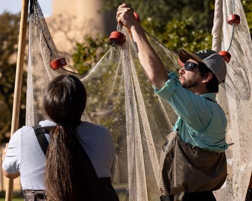Biology students examine a net at the Lake at The University of Texas at Tyler