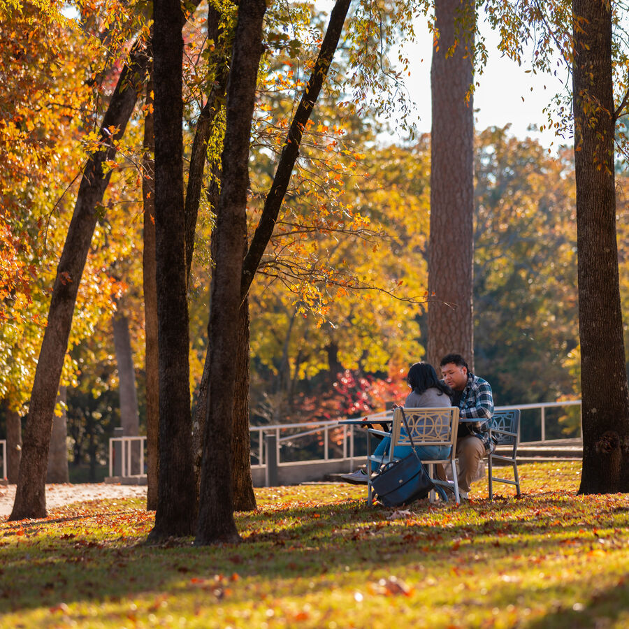 Two students talking outdoors at UT Tyler's main campus during fall