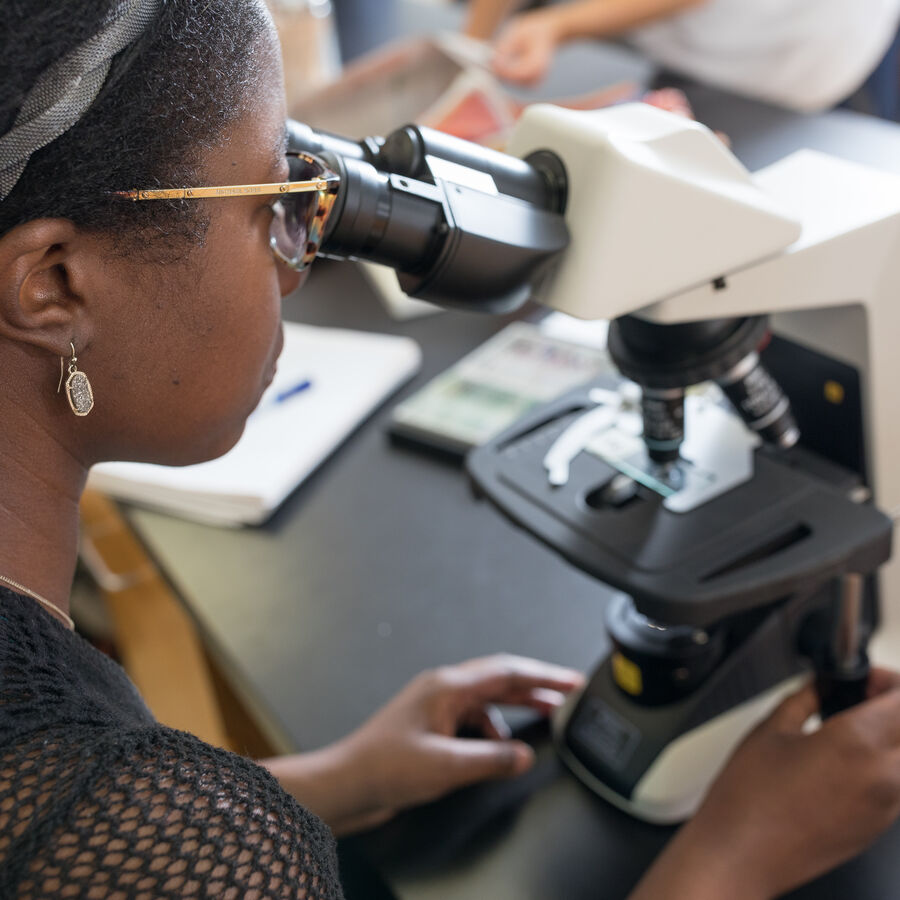 A student with a microscope at a microbiology class at the University of Texas at Tyler