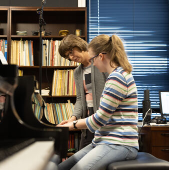 teacher instructing piano student
