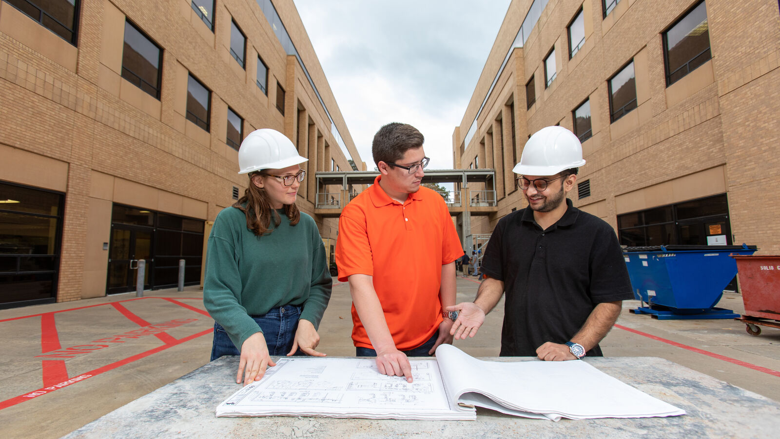 Three MS in Civil Engineering Students look at construction plans for a project at UT Tyler