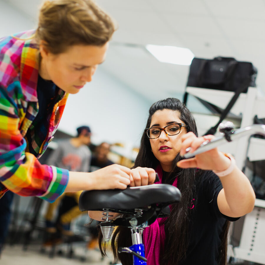 Two women inspect a bicycle in an engineering class at UT Tyler's Houston Engineering Center