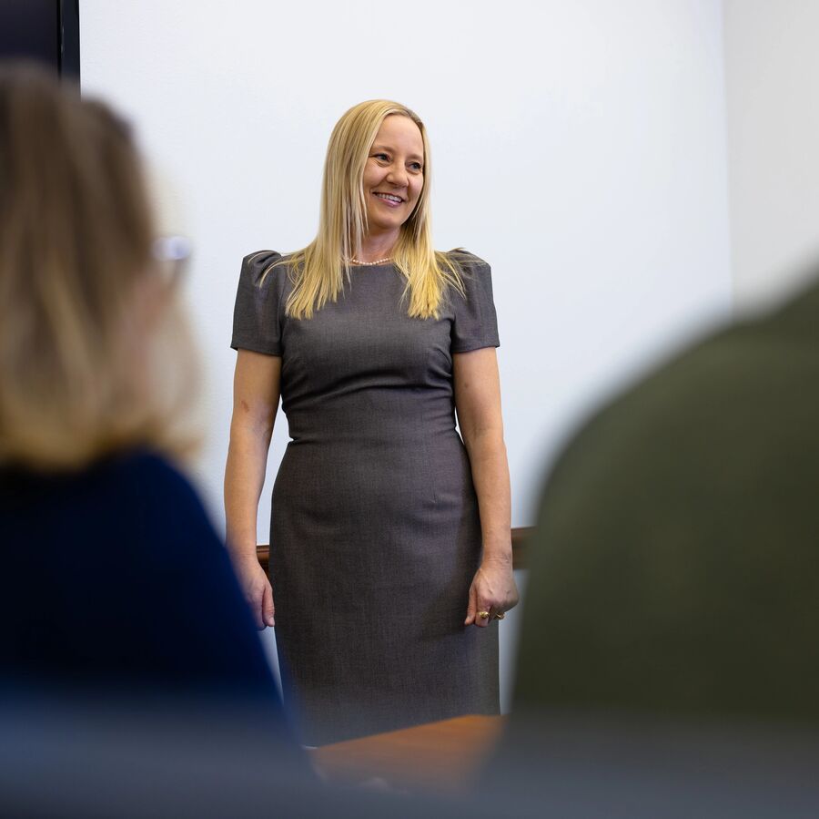A female School of Nursing graduate student stands in front of a classroom during a presentation