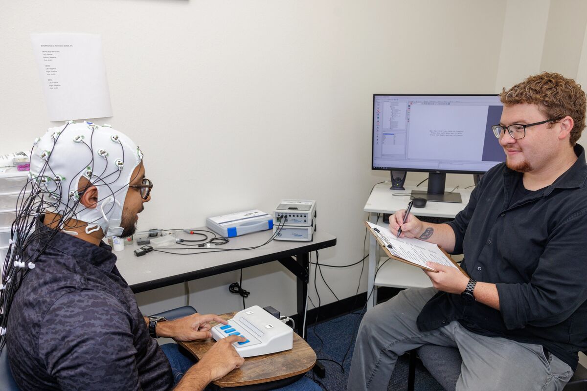 Psychologists analyzing cognitive behavior from a participant with specialized equipment