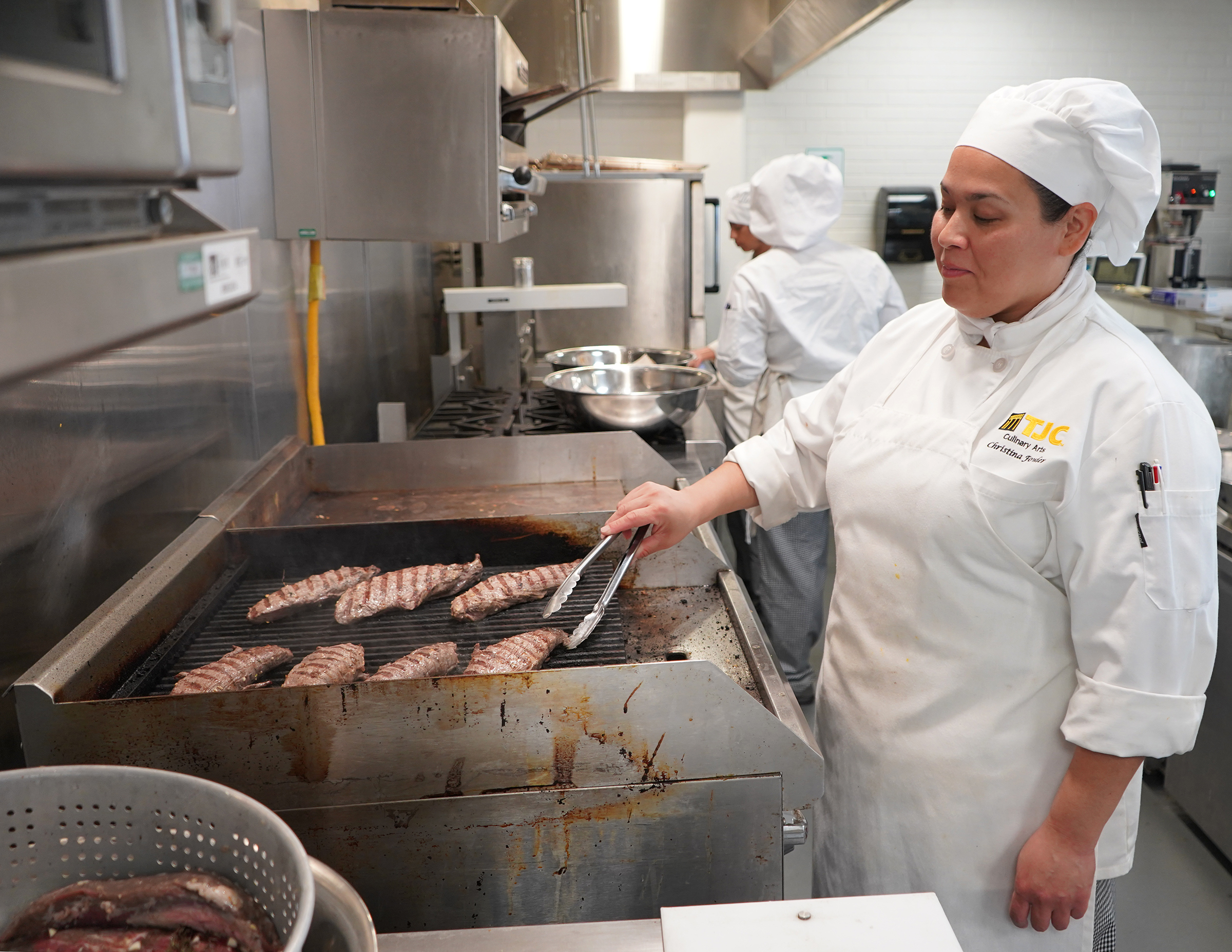 Christina Fowler, a TJC Culinary Arts student from Van, prepares steaks in advance of Tuesday’s Cowan Center event.