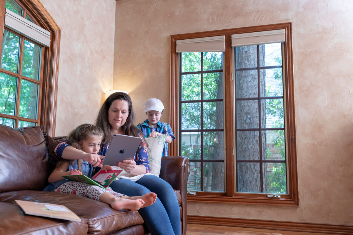 Student at home with two kids around her working on school work