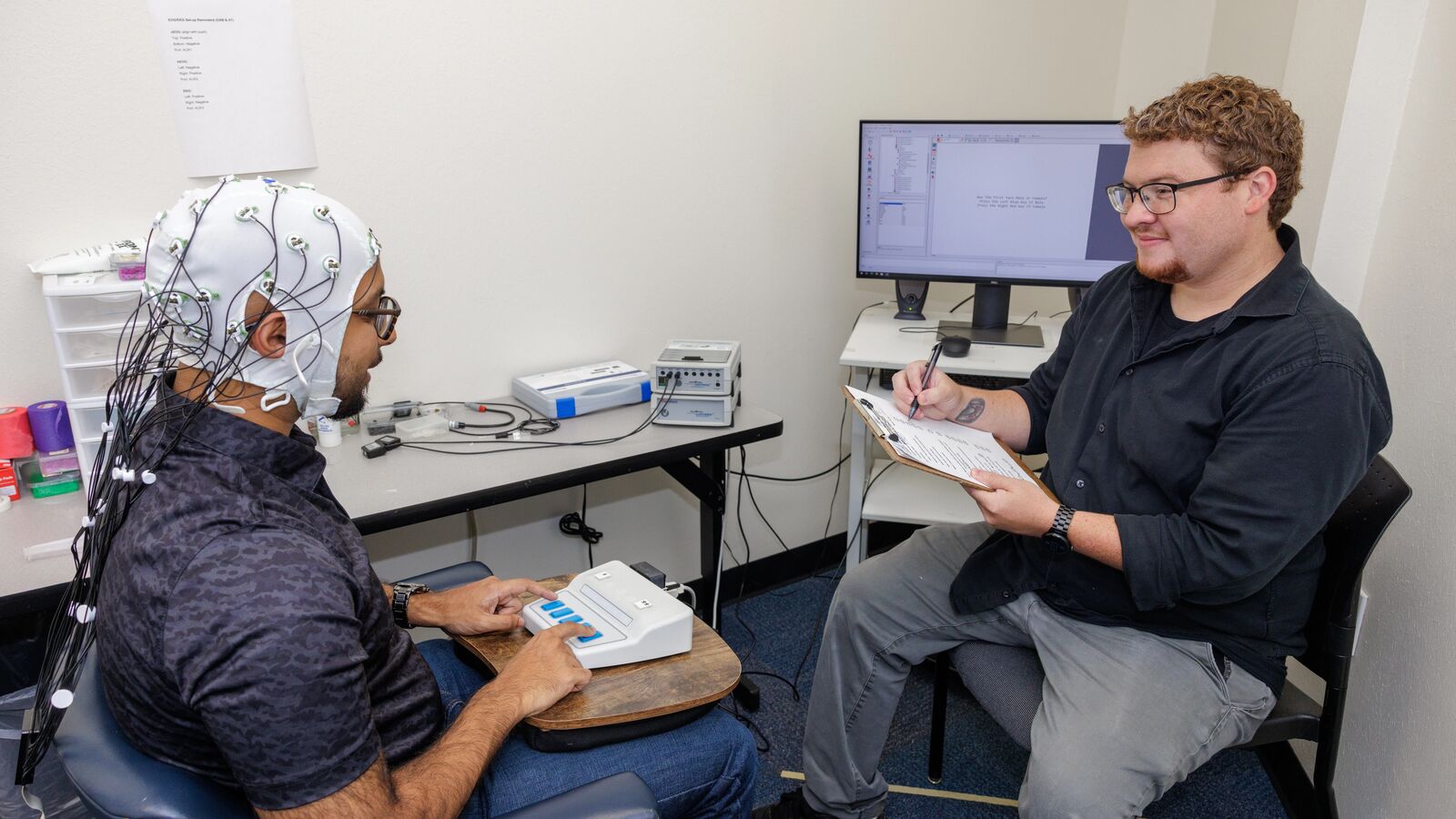 Patient sitting with worker doing a study