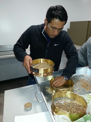 A student uses sieves in soil mechanics