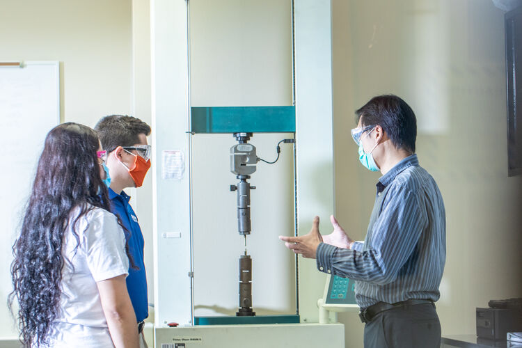 Two students checking out a piece of Mechanical Engineering equipment