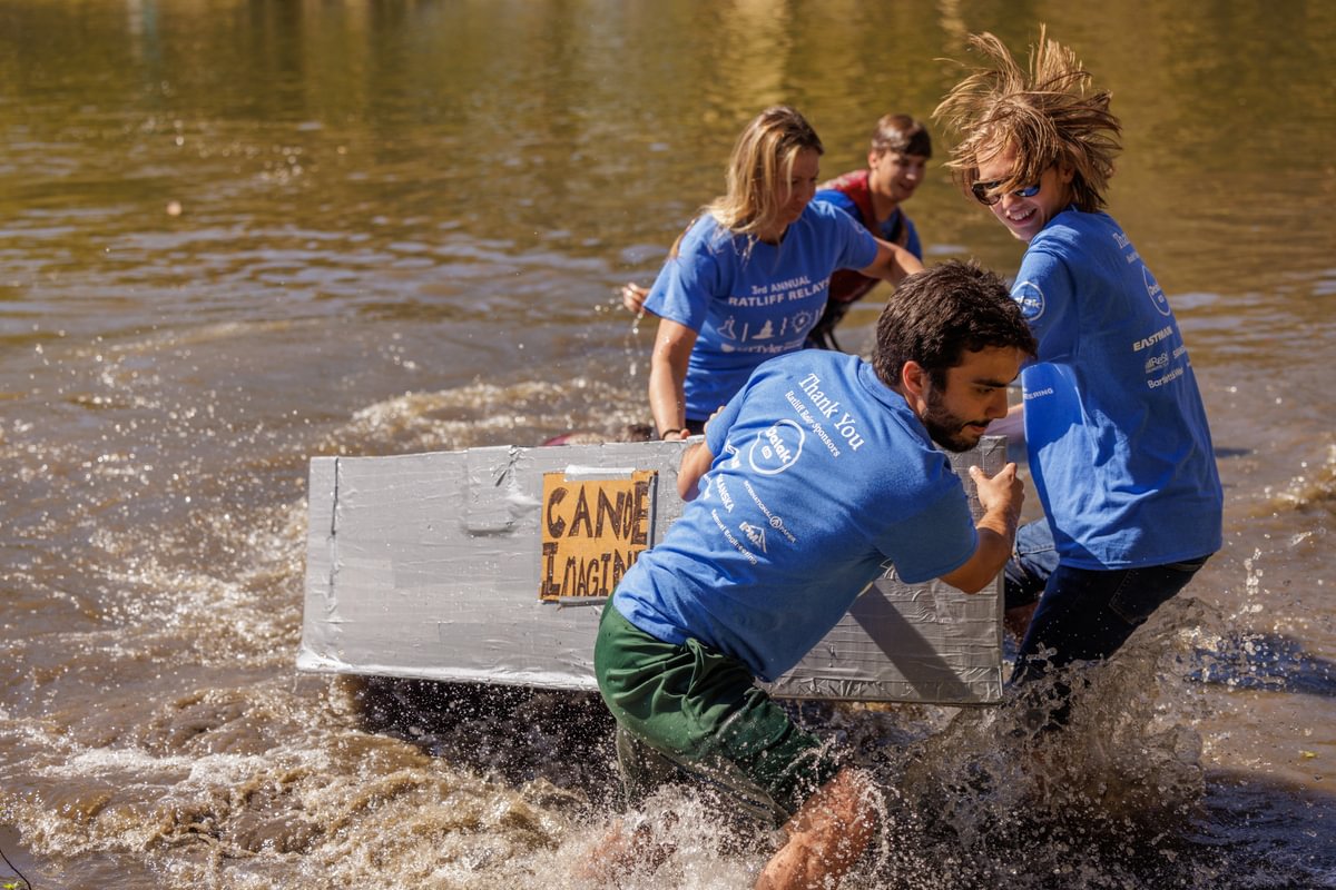 students pulling their canoe out of the lake