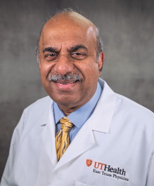 man wearing a white coat with a light blue undershirt and yellow tie. 