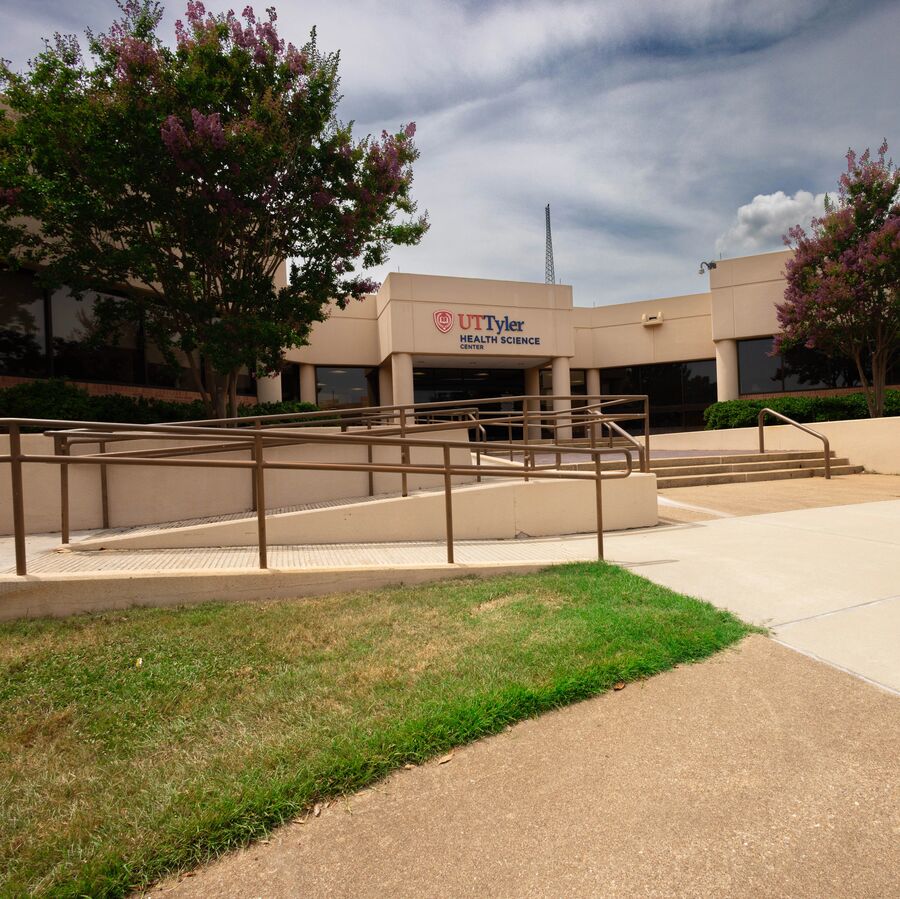 Building exterior of UT Tyler Health Science Center with ramp and flowering trees