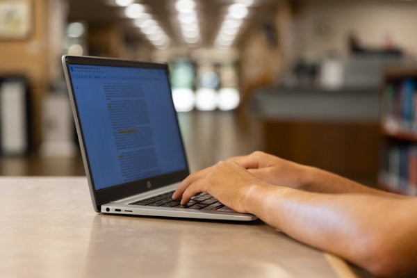 Student typing on a laptop