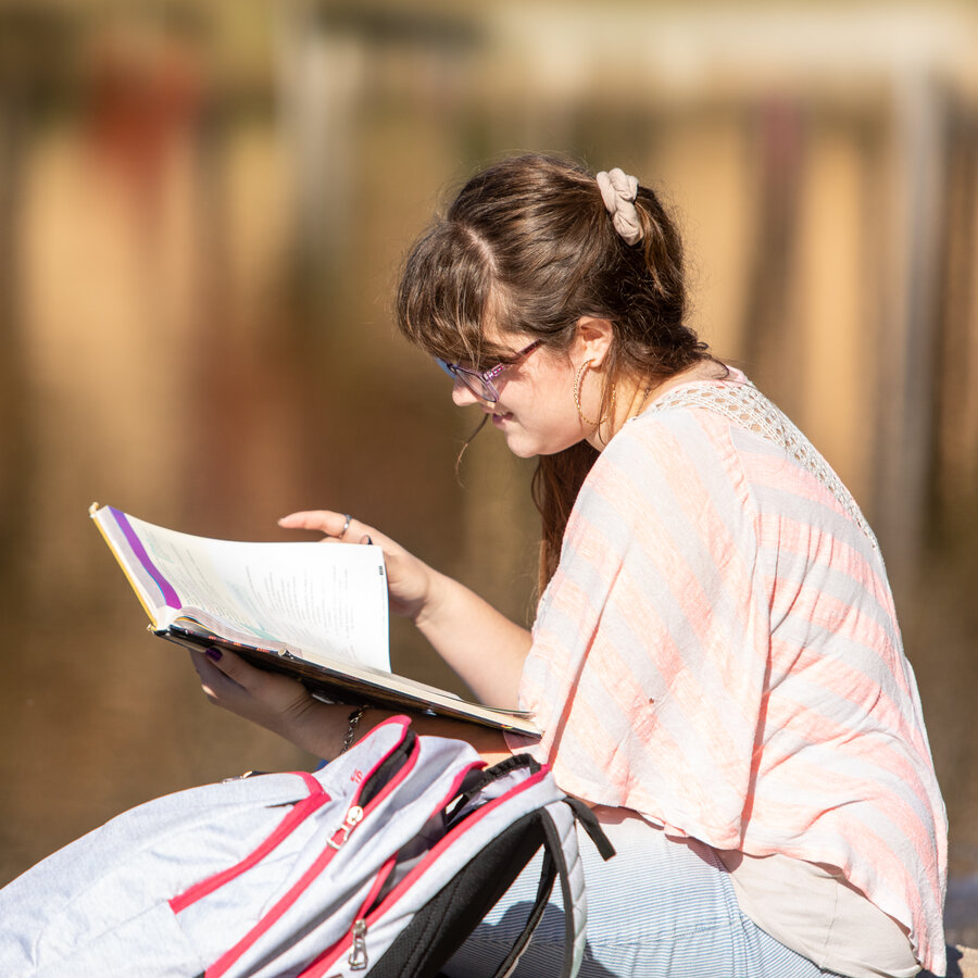 student studying by the lake