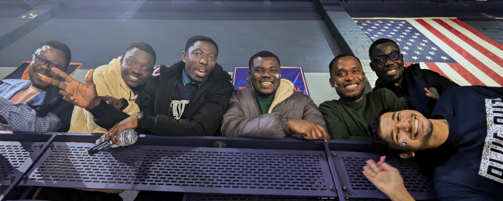 Group of students smiling looking down from bleachers. 