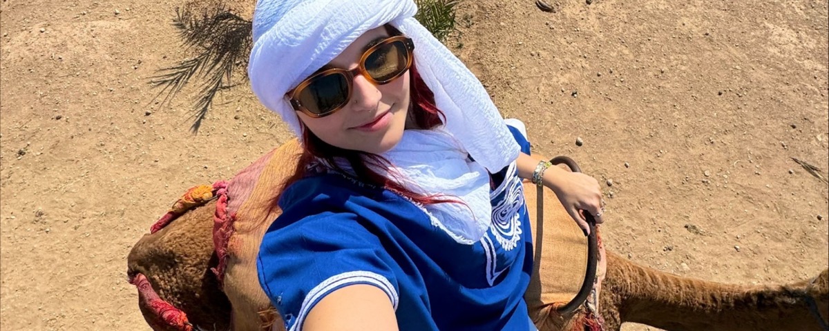 Student riding camelback in the Saharan desert.