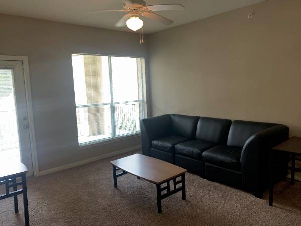 Four Bedroom Two Bathroom Living Room with open window and black couch