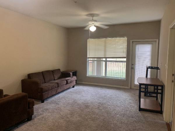 Living room with couch and windows in background