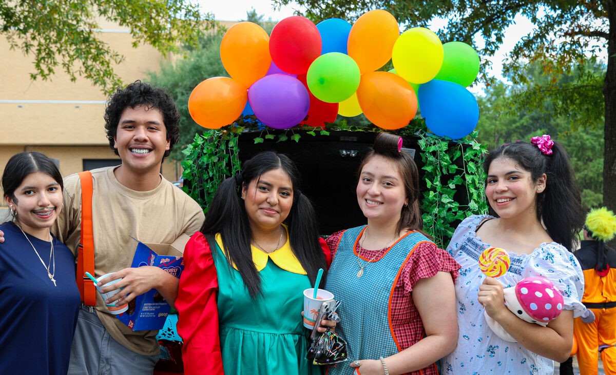 A group of students around a decorated car trunk at trunk or treat